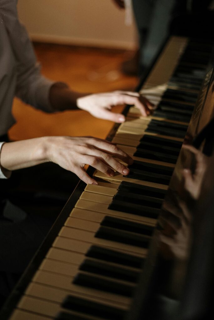 Close-up of hands playing piano in a warm, cozy home environment, capturing artistic elegance.